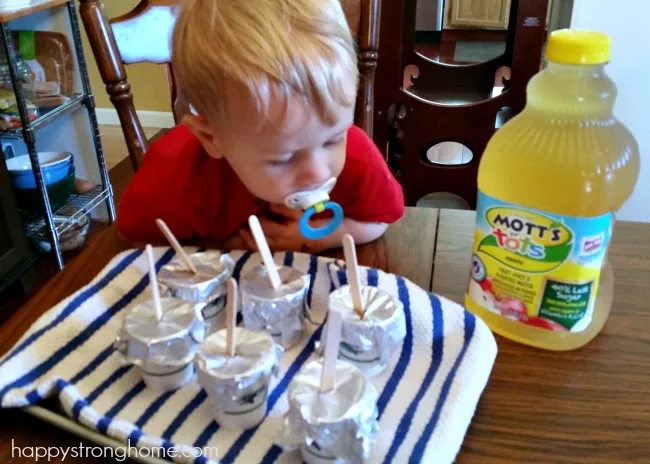 toddler looking at DIY Frozen pops on a table