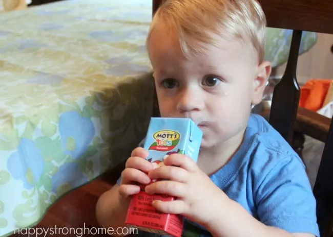 toddler with apple juice box