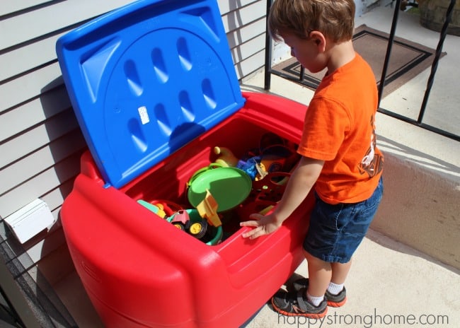 A little boy standing in front of a box