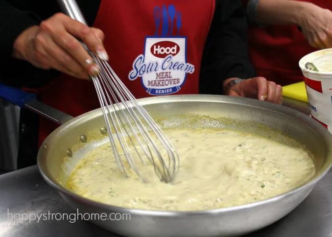 Whisking creamy pumpkin soup in a metal pan