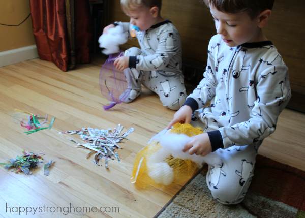 Two boys sitting on floor building nesting bags