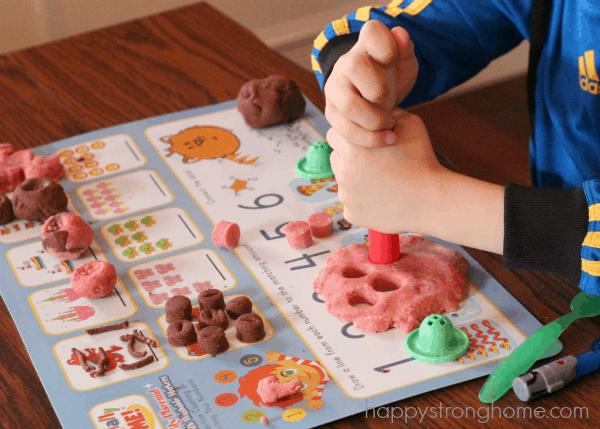 Close up of hands playing with playdough on a placemat