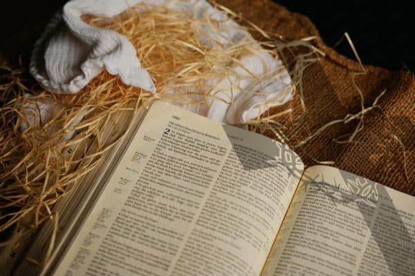 An open Bible laying on hay