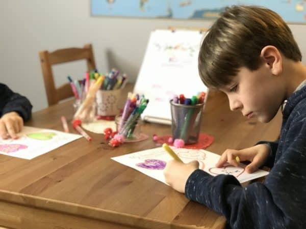 Child working on a Valentine\'s worksheet at a table