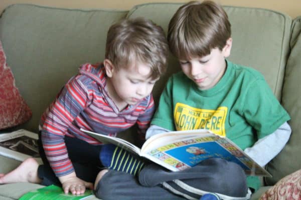 Boys reading books on a couch