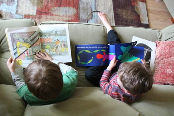 Overhead shot of boys on a couch reading picture books