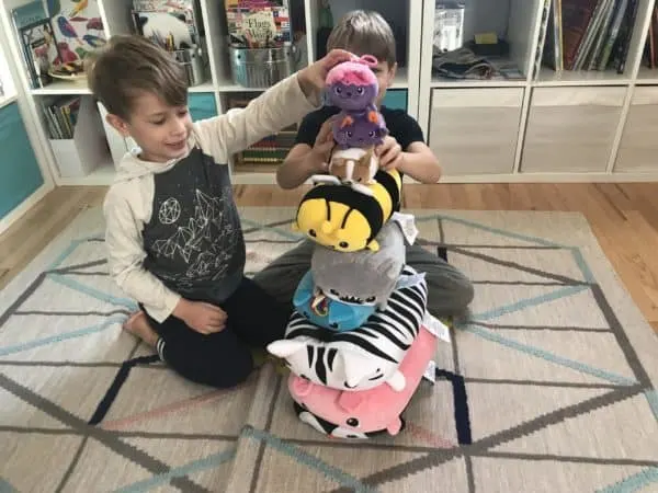 Kids playing with a stack of stuffed animals