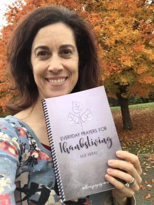 A woman holding a book posing for the camera