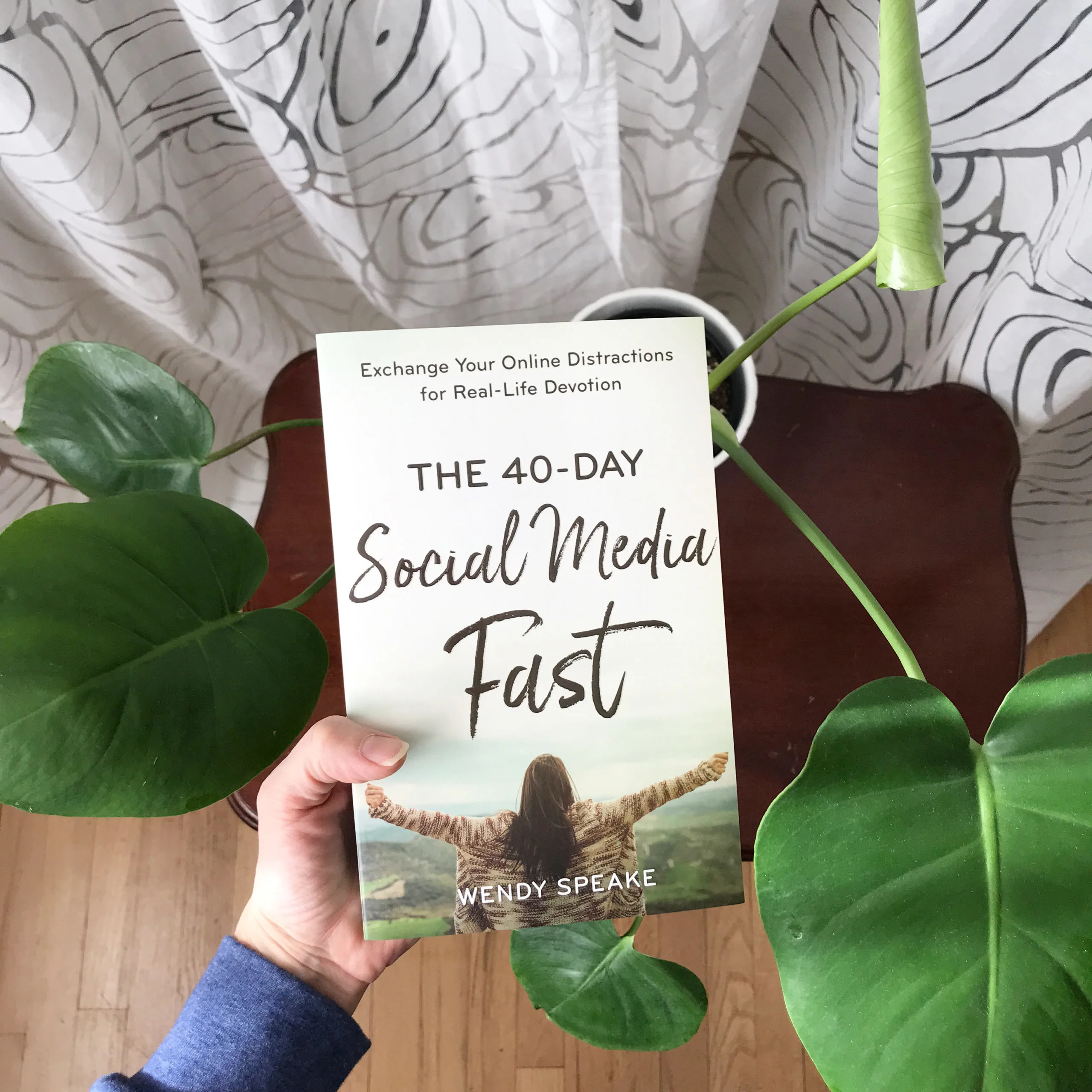 40 Day Social Media Fast Book held near monstera plant