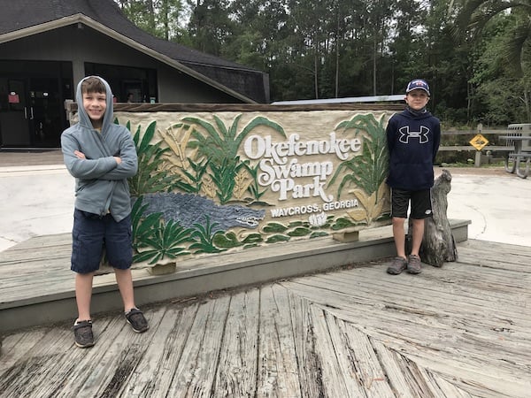 A boy standing in front of a sign for park