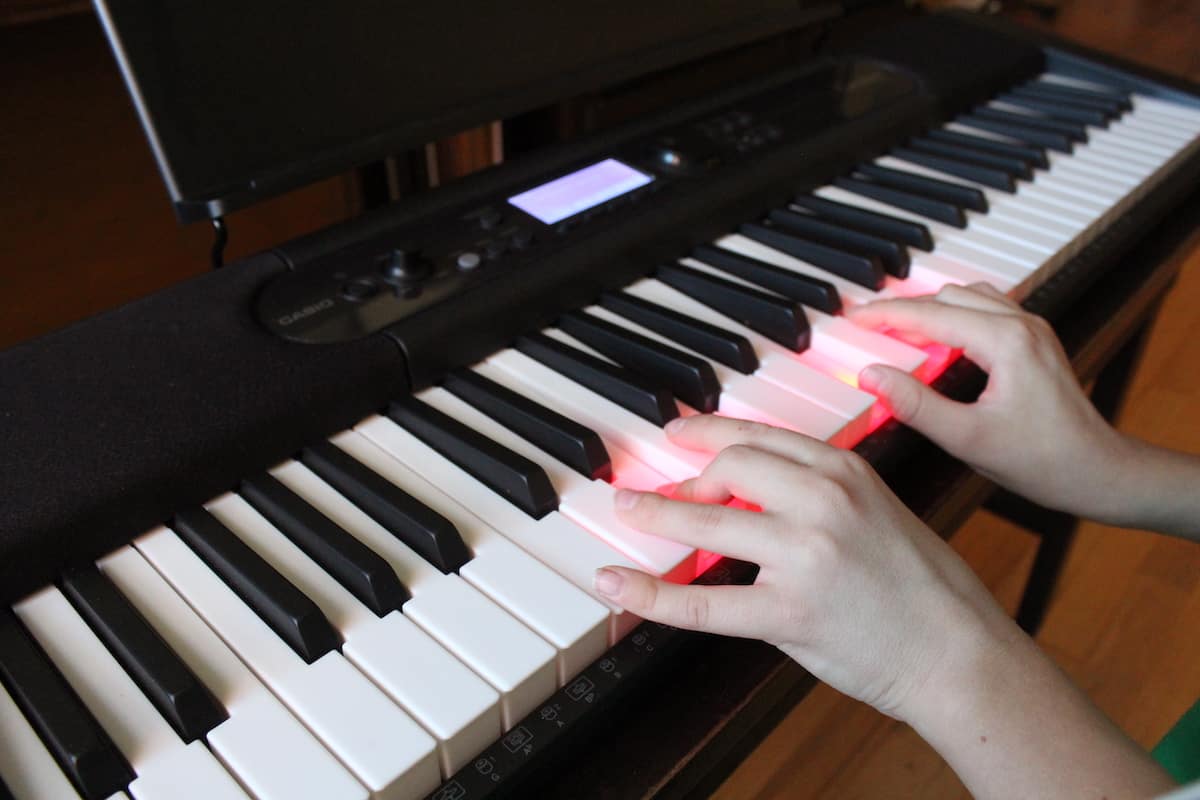 hands playing a piano keyboard