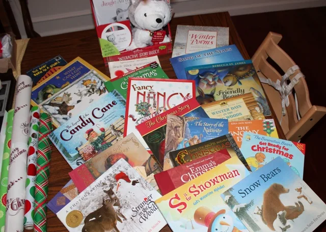 Dozens of Christmas Read-Aloud Books layered on a table