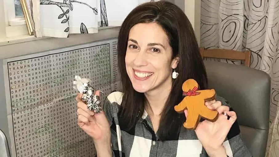 A woman holding a wooden toy posing for the camera